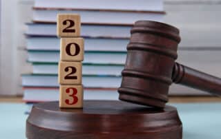 figures of the year 2023 on wooden cubes against the background of the judge's hammer and stand