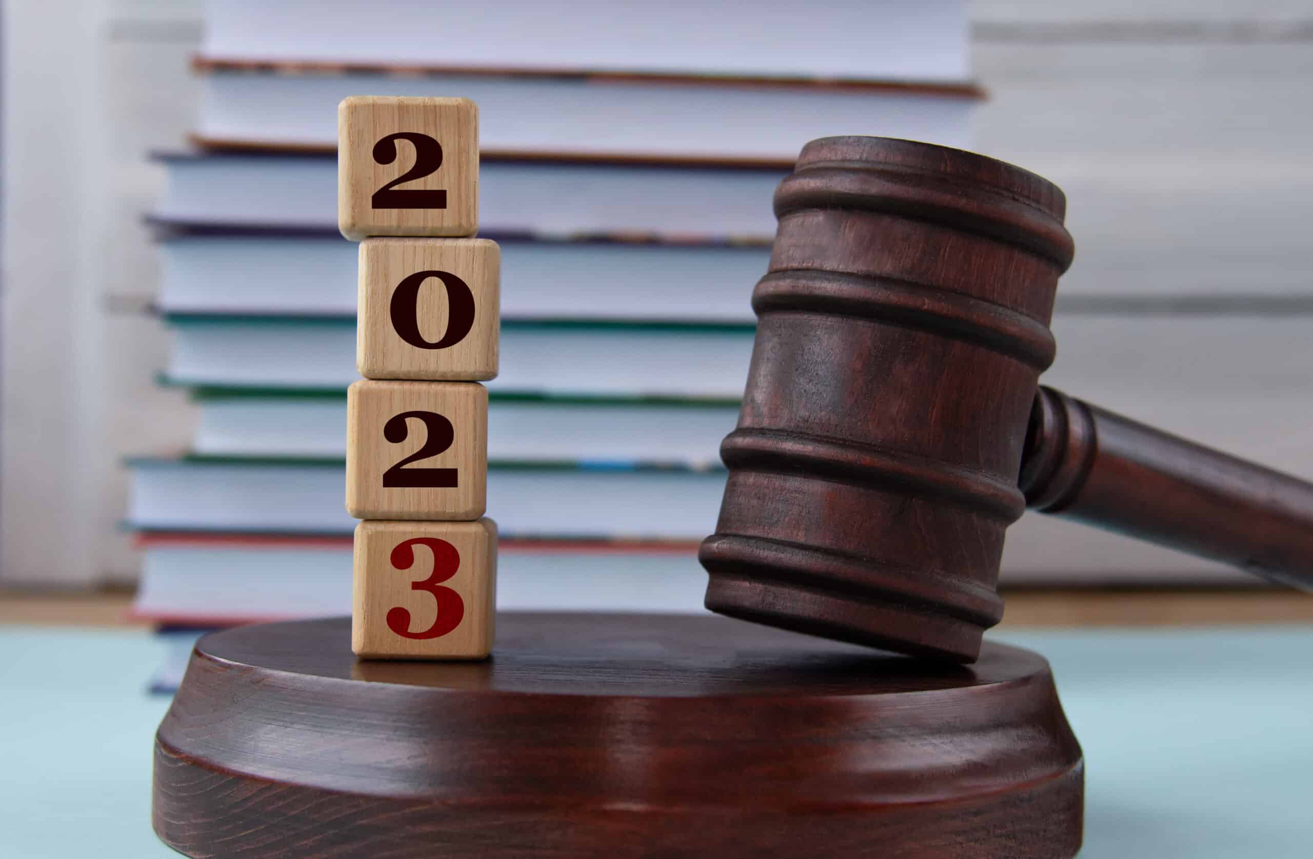 figures of the year 2023 on wooden cubes against the background of the judge's hammer and stand