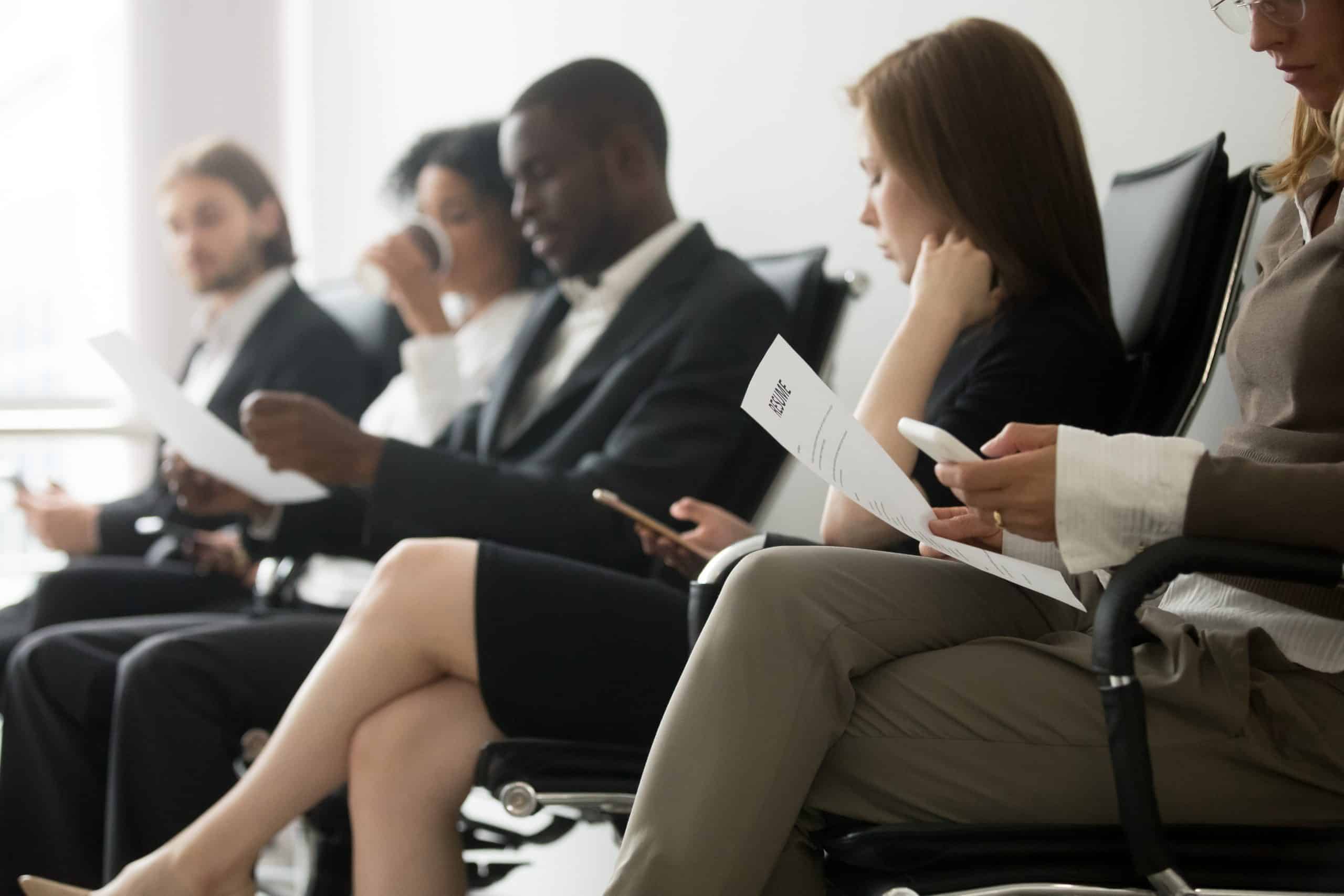 Multi-ethnic applicants sitting in queue waiting for job interview